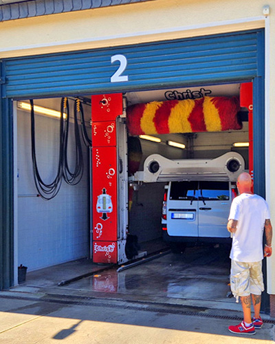 Eine Person steht an der Waschanlage von Hoth Brennstoffhandel während sein Auto gewaschen wird. Eine Person steht an der Waschanlage von Hoth Brennstoffhandel während sein Auto gewaschen wird.